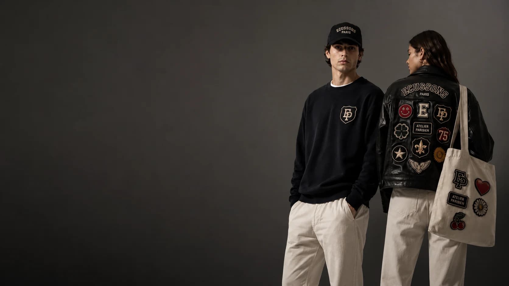 Duo portant des écussons brodés personnalisés Écussons Paris : casquette, sweat, veste en cuir et tote bag ornés de patchs