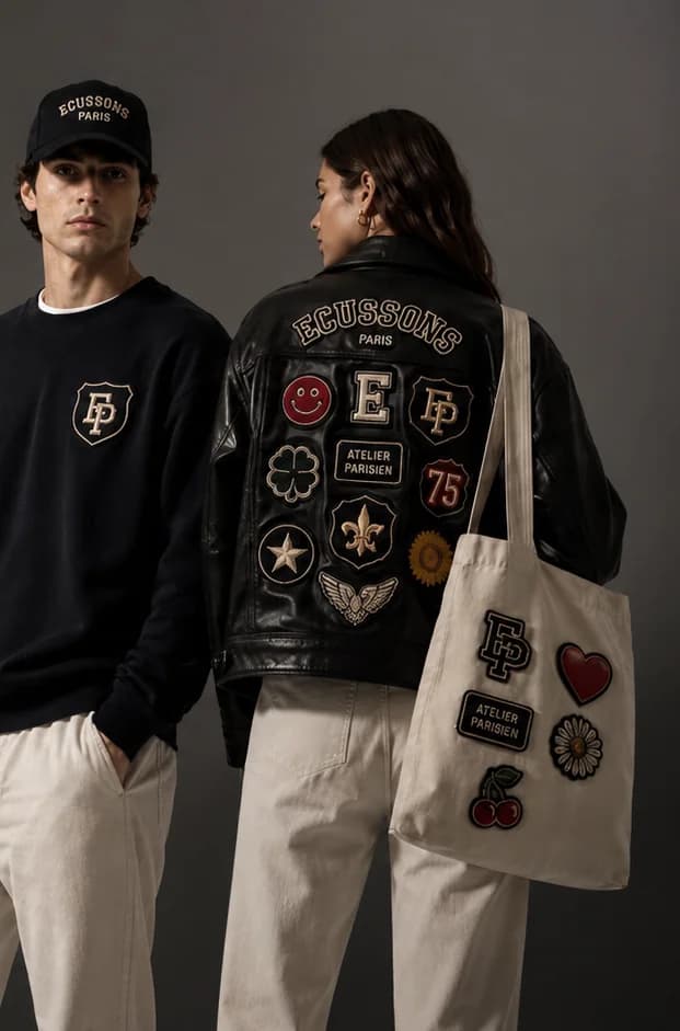 Duo portant des écussons brodés personnalisés Écussons Paris : casquette, sweat, veste en cuir et tote bag ornés de patchs
